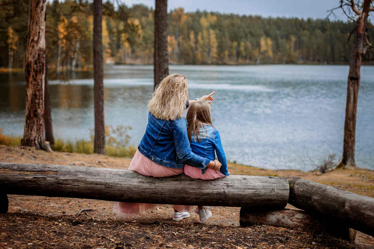 kızı ile nehir kenarında oturan anne