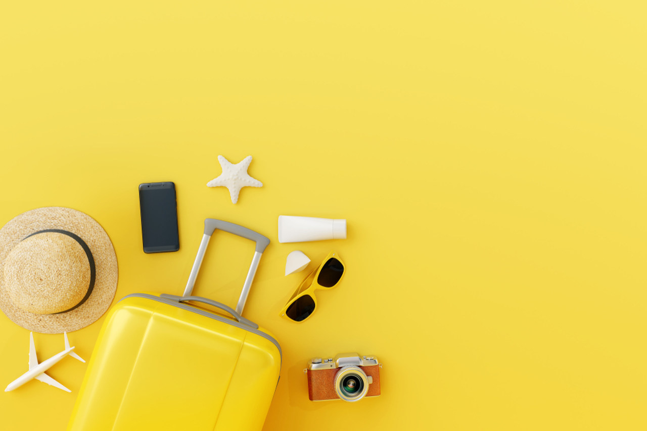 sarı bavul ve tatili temsil eden objeler